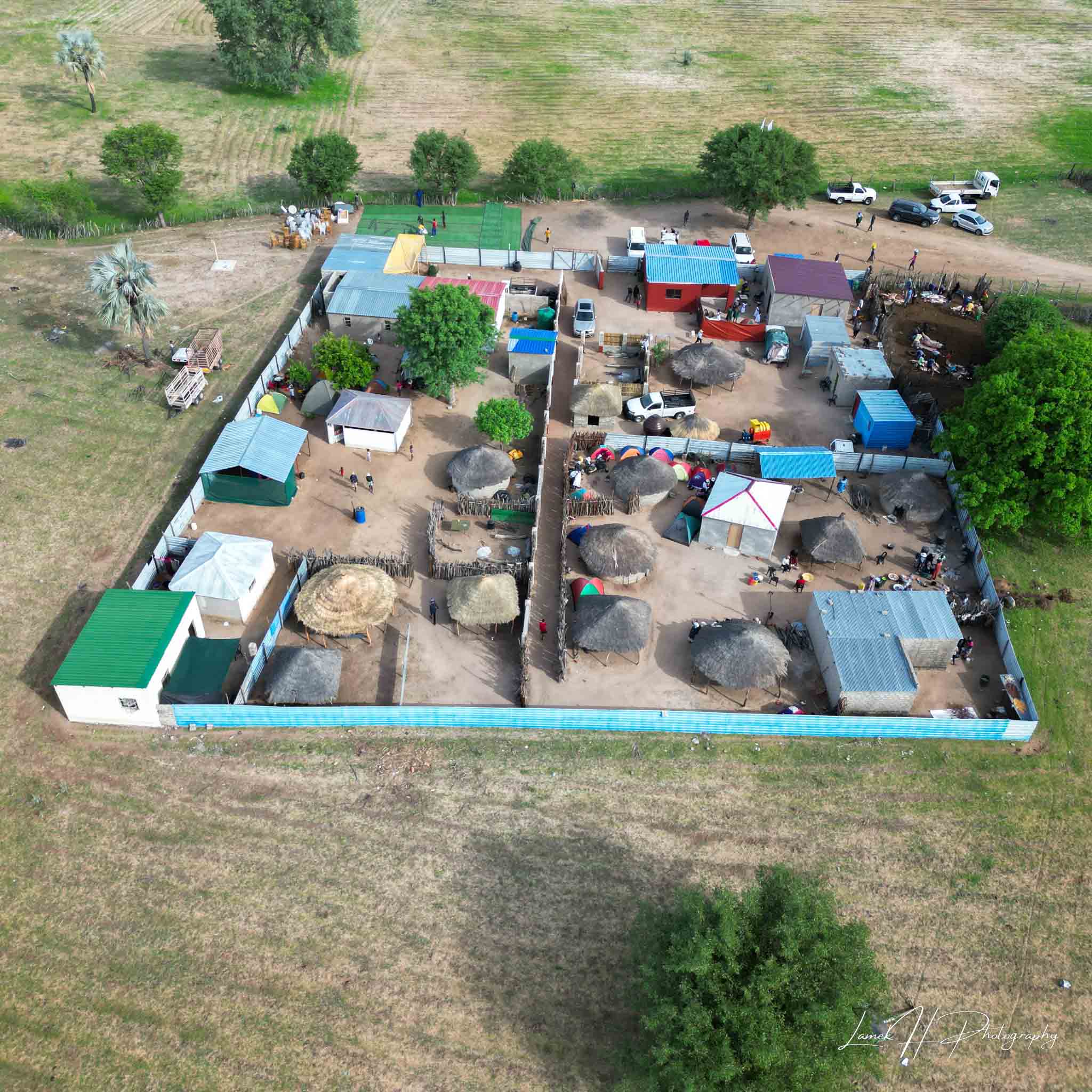 Drone shot of a winding road cutting through green mountains